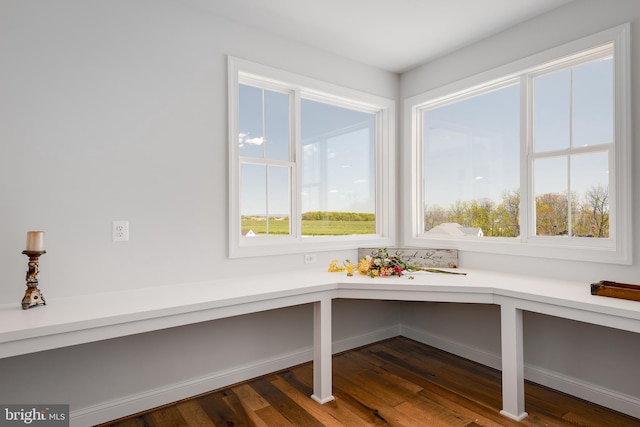 unfurnished room with dark wood-type flooring and built in desk