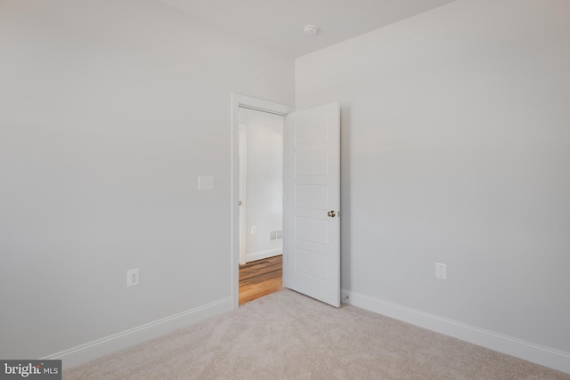 unfurnished room featuring light carpet