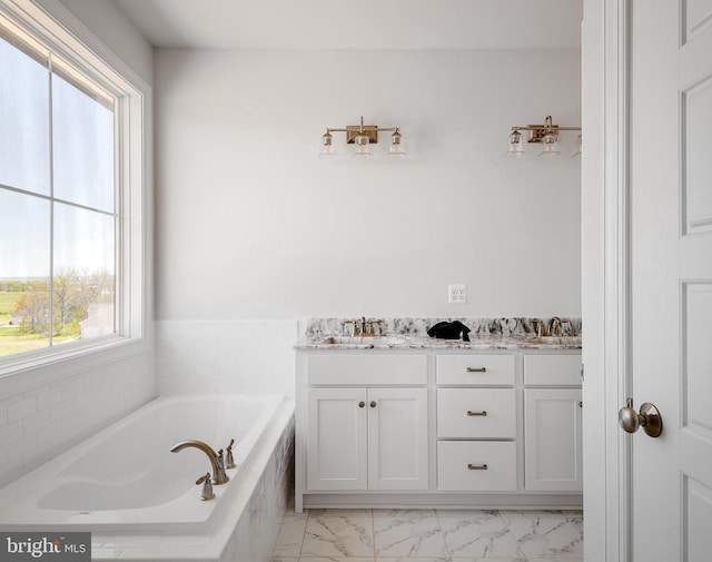 bathroom with vanity and tiled tub