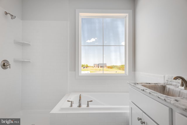 bathroom featuring vanity and tiled tub