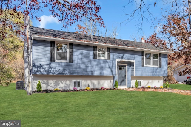 split foyer home with cooling unit and a front lawn