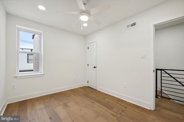 spare room with ceiling fan and light wood-type flooring