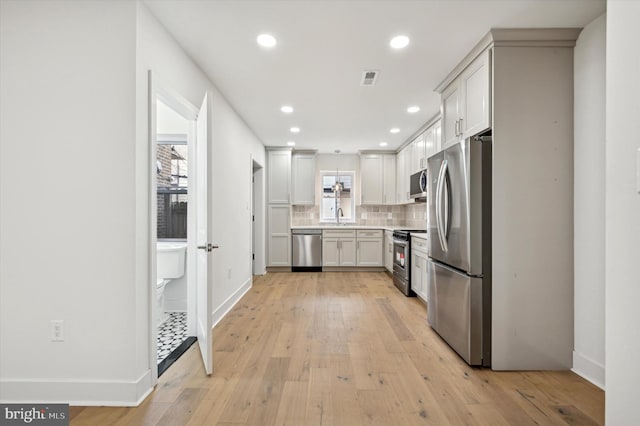 kitchen with light hardwood / wood-style floors, sink, white cabinetry, and stainless steel appliances