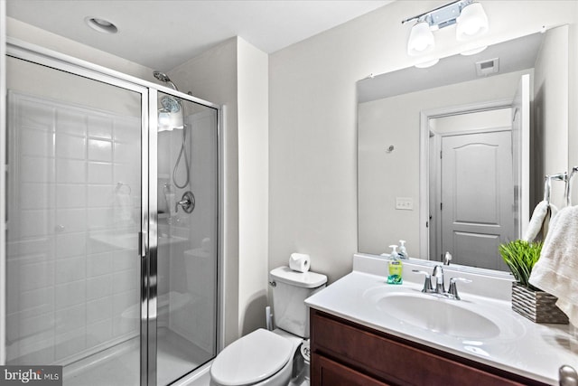 bathroom with vanity, toilet, and a shower with shower door