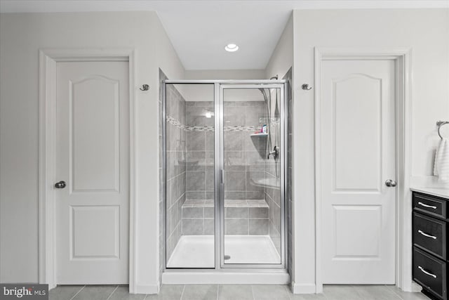 bathroom featuring tile patterned flooring, vanity, and a shower with door