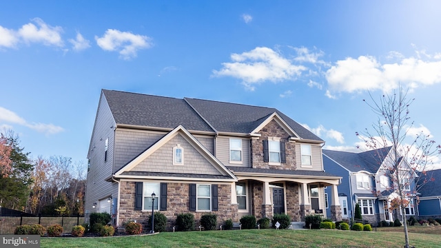 craftsman inspired home featuring a porch, a front yard, and a garage