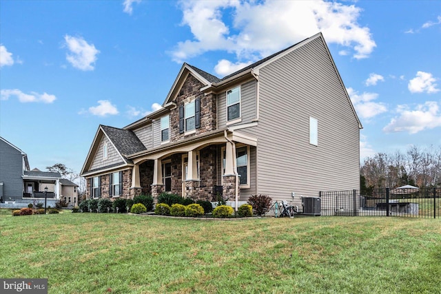 craftsman-style house with central air condition unit and a front yard