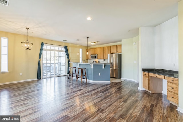 kitchen featuring dark hardwood / wood-style floors, stainless steel appliances, and decorative light fixtures