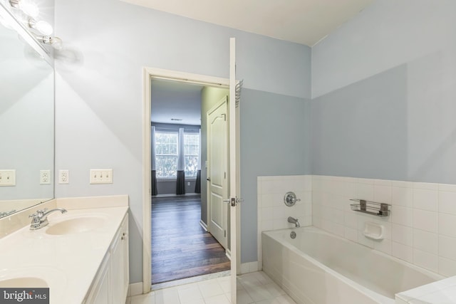 bathroom featuring a tub, hardwood / wood-style floors, and vanity