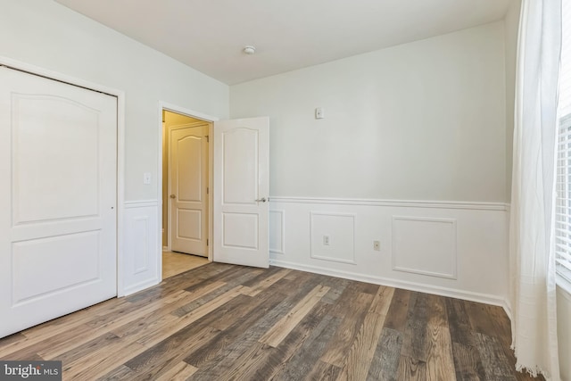 unfurnished bedroom featuring dark hardwood / wood-style flooring and a closet