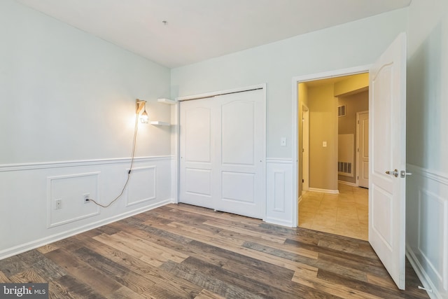 unfurnished bedroom featuring a closet and dark hardwood / wood-style flooring