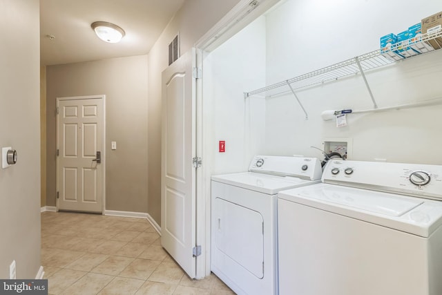 laundry area featuring washing machine and dryer and light tile patterned floors