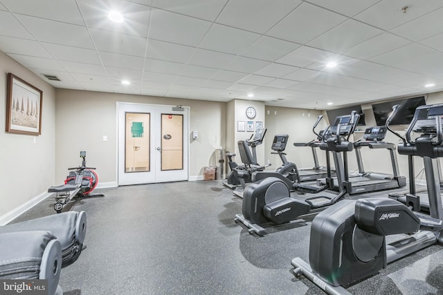 gym with a paneled ceiling and french doors