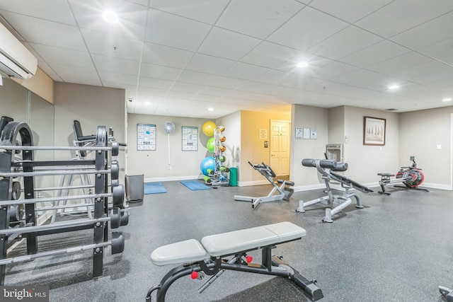 exercise room featuring a paneled ceiling and a wall mounted AC