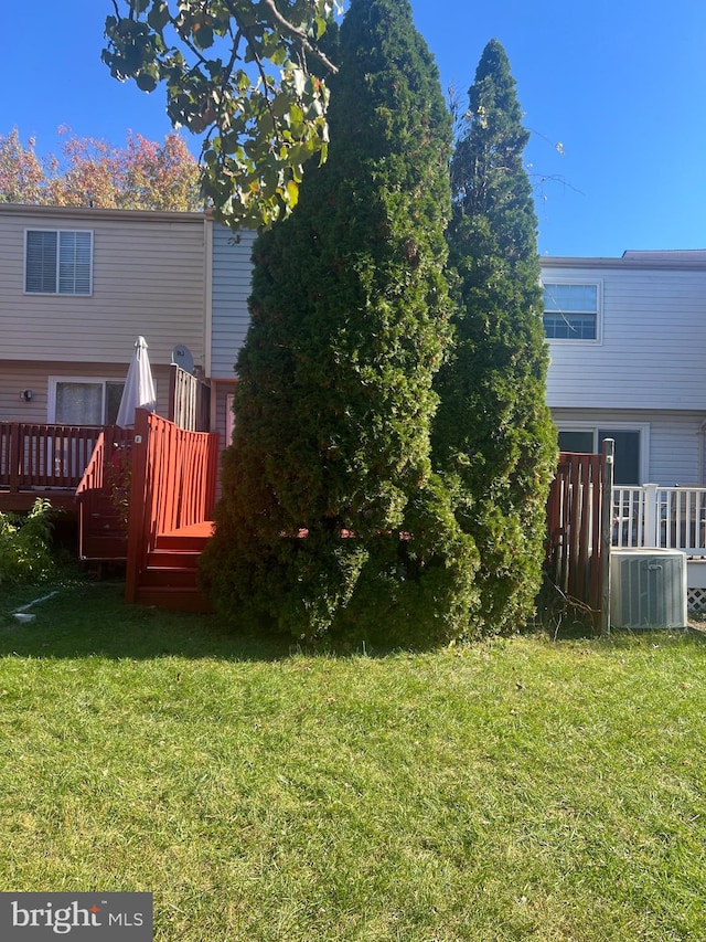 view of yard featuring a deck and central AC unit