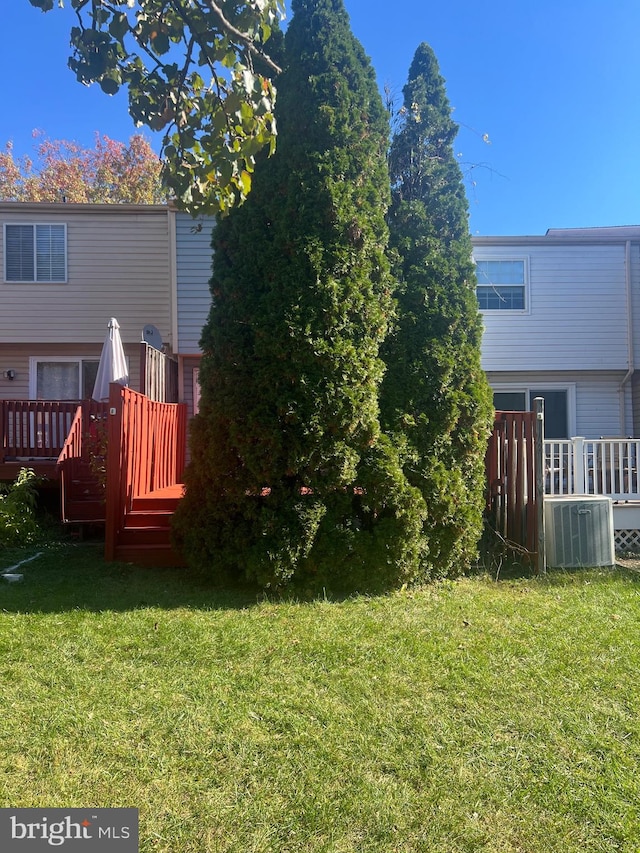 view of yard with central AC unit and a wooden deck