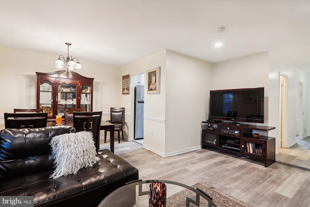 living room with a chandelier and light wood-type flooring