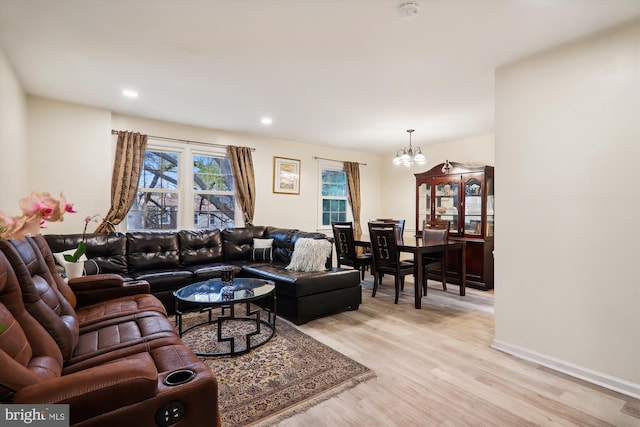 living room featuring light wood-type flooring and a notable chandelier