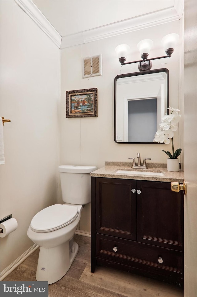 bathroom with hardwood / wood-style floors, vanity, toilet, and crown molding