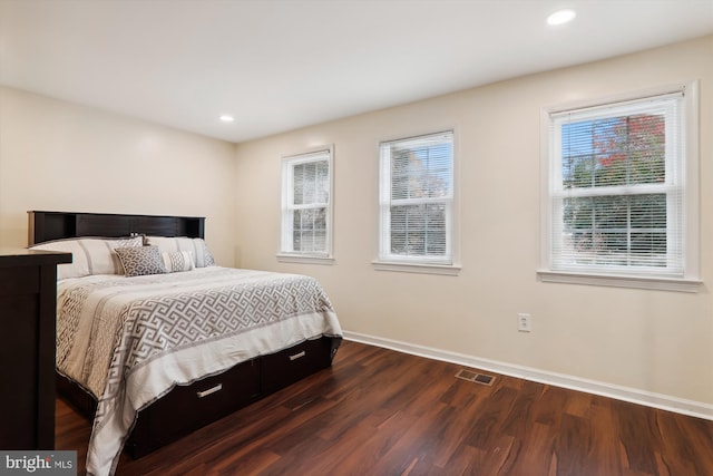 bedroom with dark wood-type flooring and multiple windows