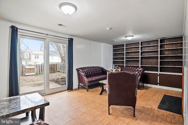 sitting room with wood walls and light parquet floors