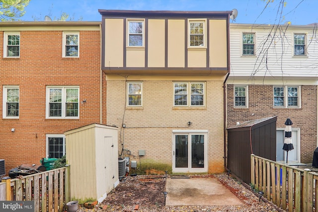 rear view of property featuring a storage unit and central air condition unit