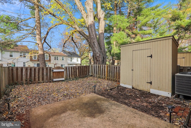 view of yard featuring a patio area, cooling unit, and a storage unit