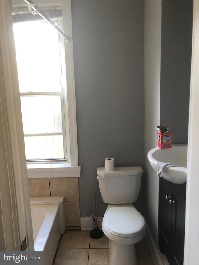 bathroom with a tub to relax in, tile patterned flooring, vanity, and toilet