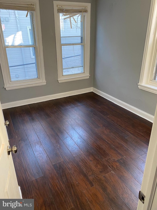 spare room featuring dark wood-type flooring