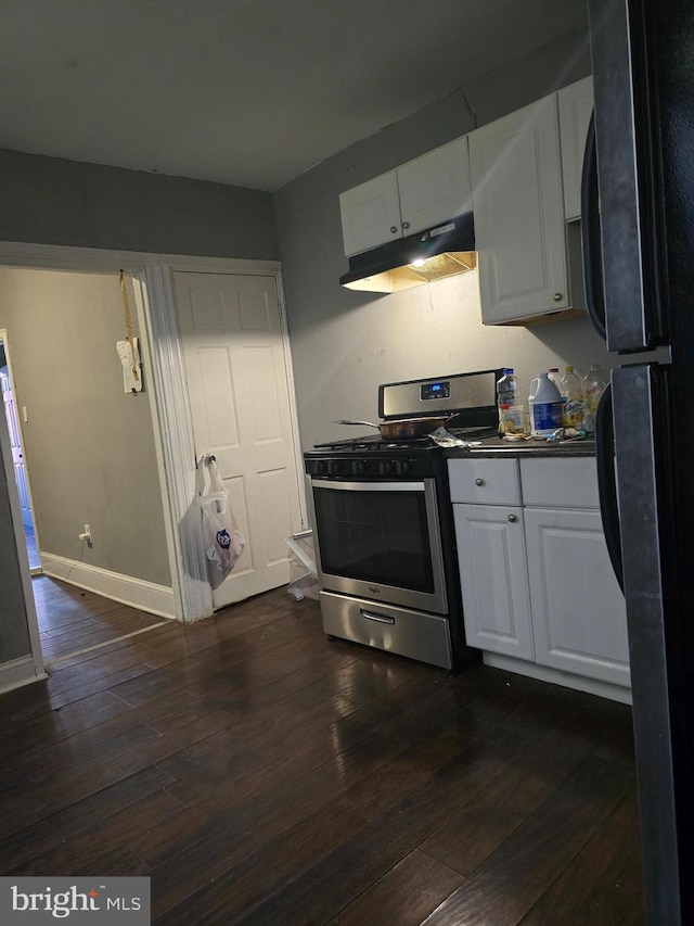 kitchen featuring black fridge, white cabinets, dark wood-type flooring, and stainless steel range with gas stovetop