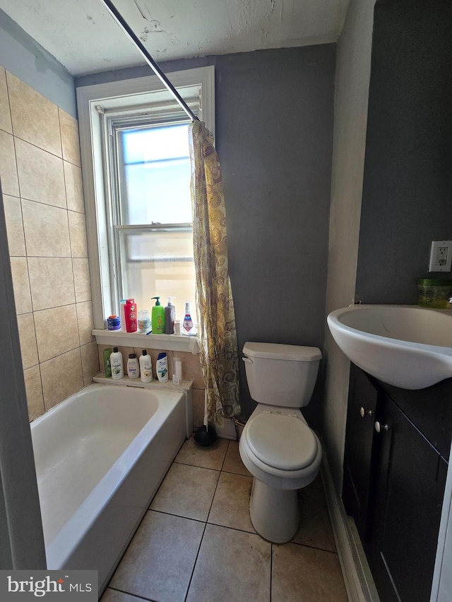 bathroom with tile patterned flooring, vanity, toilet, and a bathtub