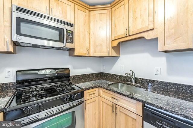 kitchen with sink, appliances with stainless steel finishes, dark stone counters, and light brown cabinets