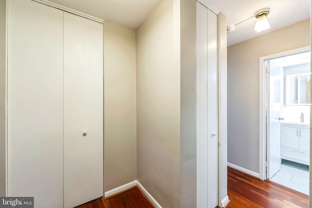 hallway with hardwood / wood-style flooring and sink