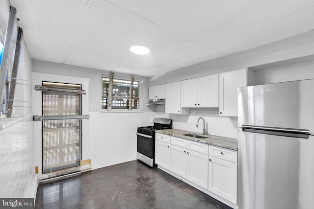 kitchen with light stone countertops, white cabinetry, sink, and appliances with stainless steel finishes