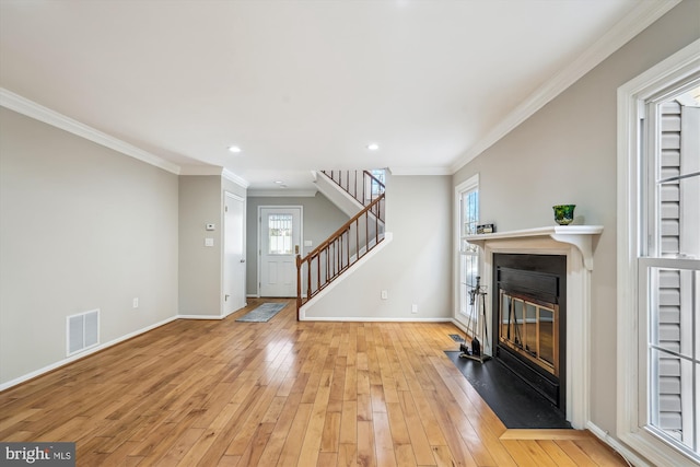 living room with light wood-type flooring and crown molding