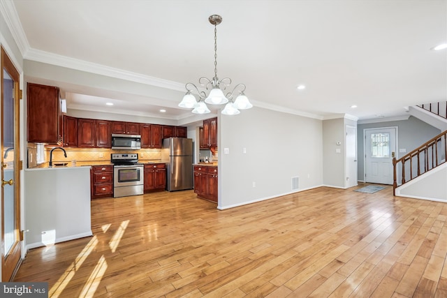 kitchen featuring a chandelier, pendant lighting, crown molding, and appliances with stainless steel finishes