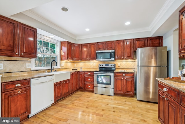 kitchen with stainless steel appliances, sink, tasteful backsplash, and crown molding