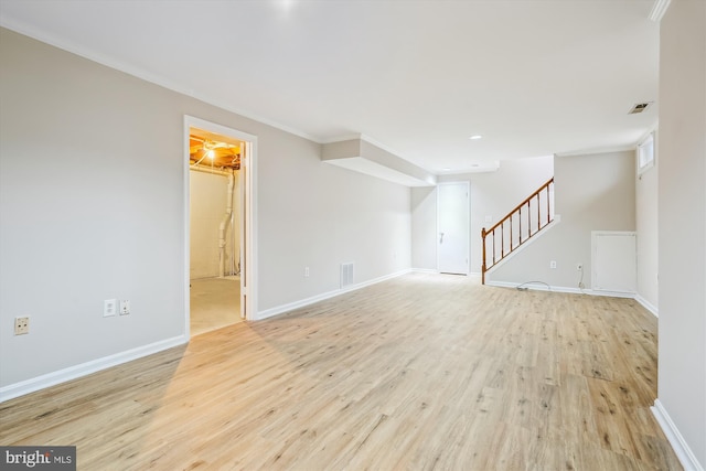 empty room with ornamental molding and light wood-type flooring