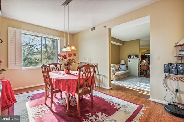 dining space with hardwood / wood-style floors