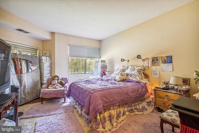 carpeted bedroom featuring a textured ceiling