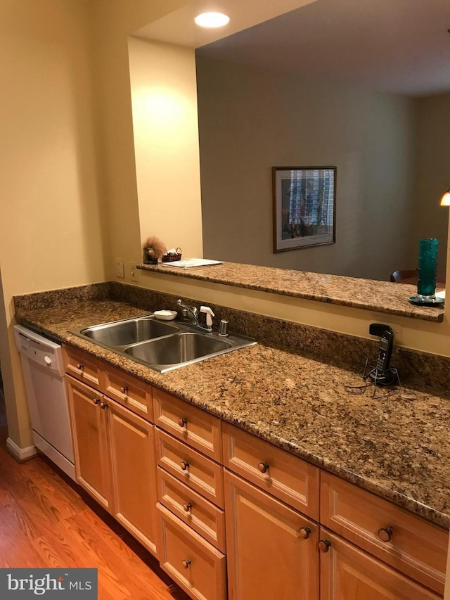 kitchen with dishwasher, light hardwood / wood-style floors, sink, and stone countertops