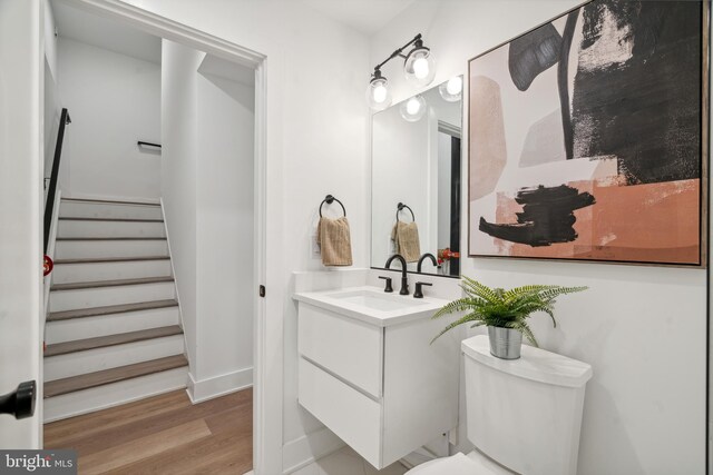 bathroom with hardwood / wood-style floors, vanity, and toilet