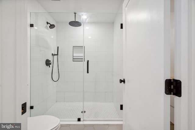 bathroom with toilet and a shower with shower door