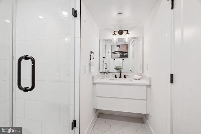 bathroom with a shower with door, vanity, and tile patterned flooring