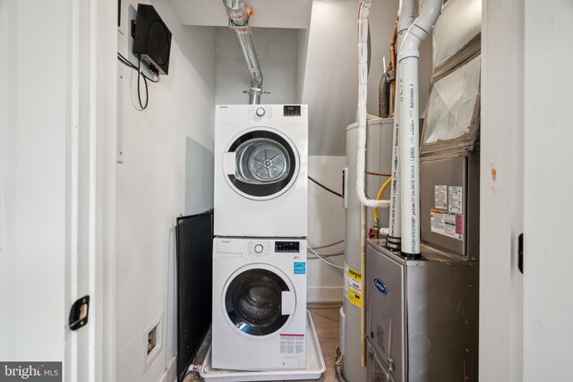 clothes washing area with stacked washer and clothes dryer and hardwood / wood-style floors