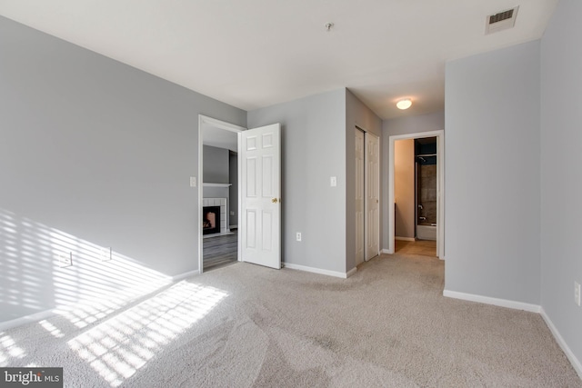 unfurnished bedroom featuring a closet and light carpet