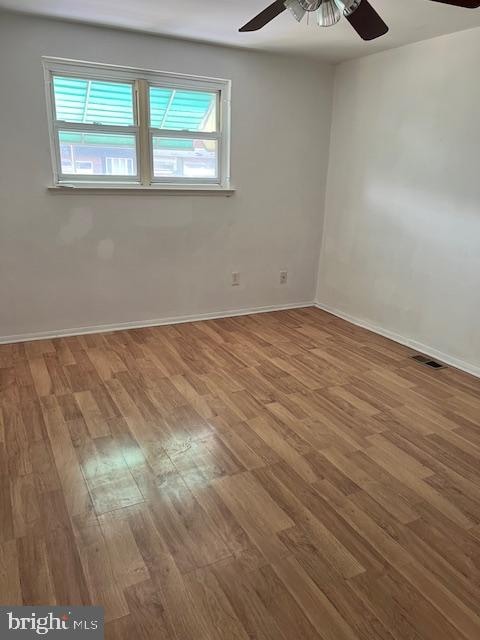 spare room with wood-type flooring and ceiling fan