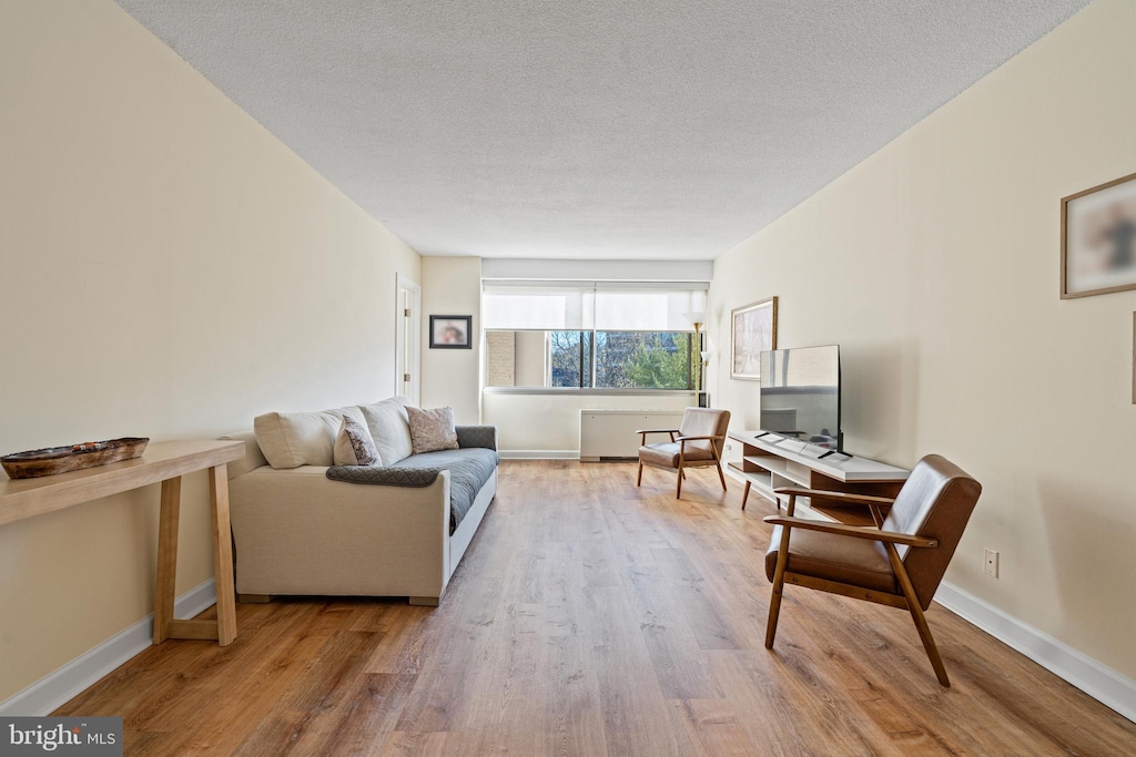 living room with wood-type flooring and a textured ceiling