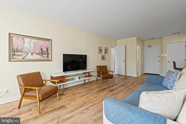 living room featuring a textured ceiling and light wood-type flooring