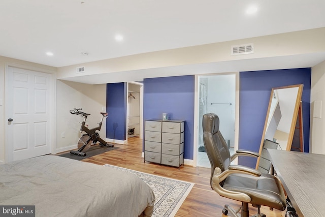 bedroom with a spacious closet, a closet, and light hardwood / wood-style floors